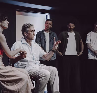 Cast taking a bow under stage lights